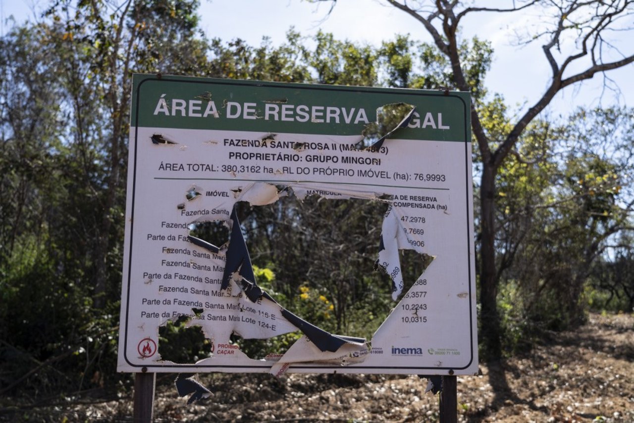 Placa de uma área de reserva natural toda destruída. A placa está em uma fazenda próxima a uma comunidade tradicional.