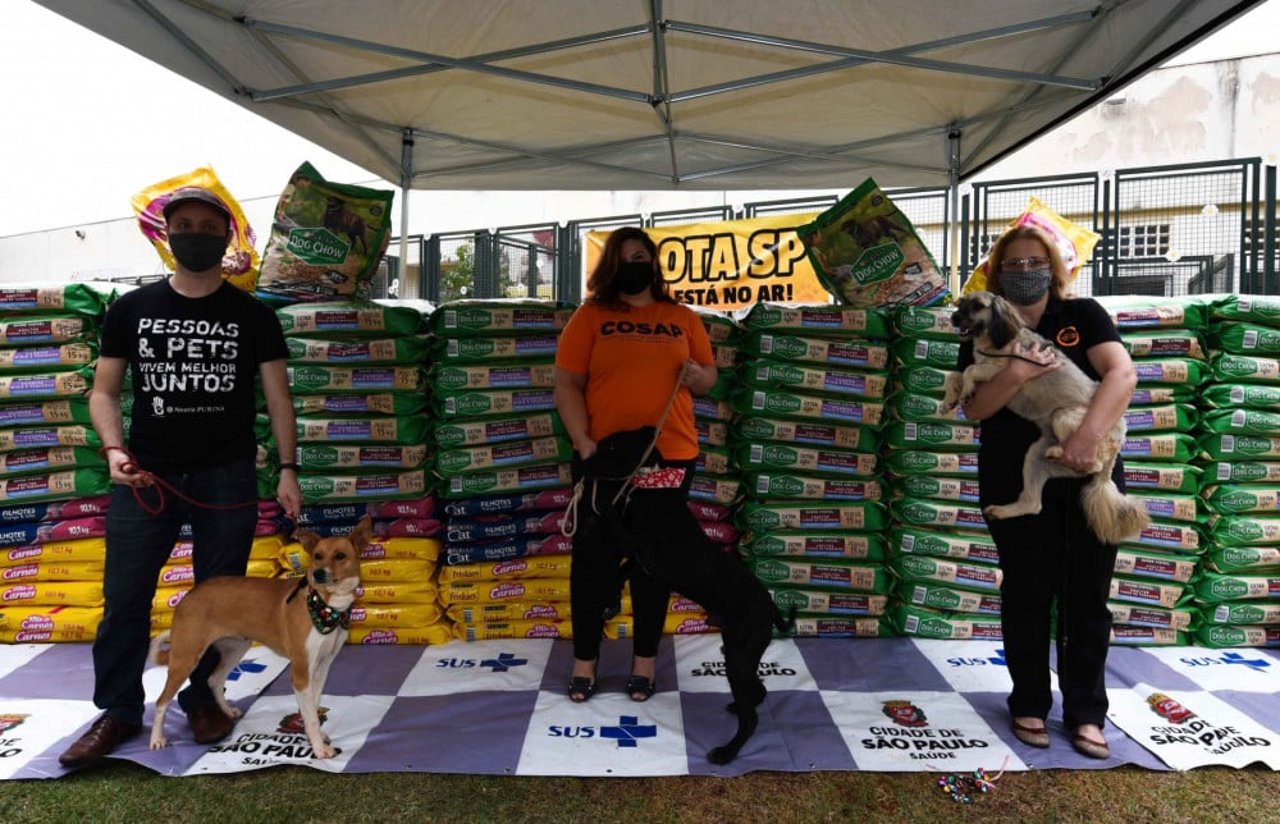 Da esquerda para direita: Diego Corradi, da Purina, entrega doações para Analy Xavier e Rosangela Ribeiro na sede da COSAP, em São Paulo.