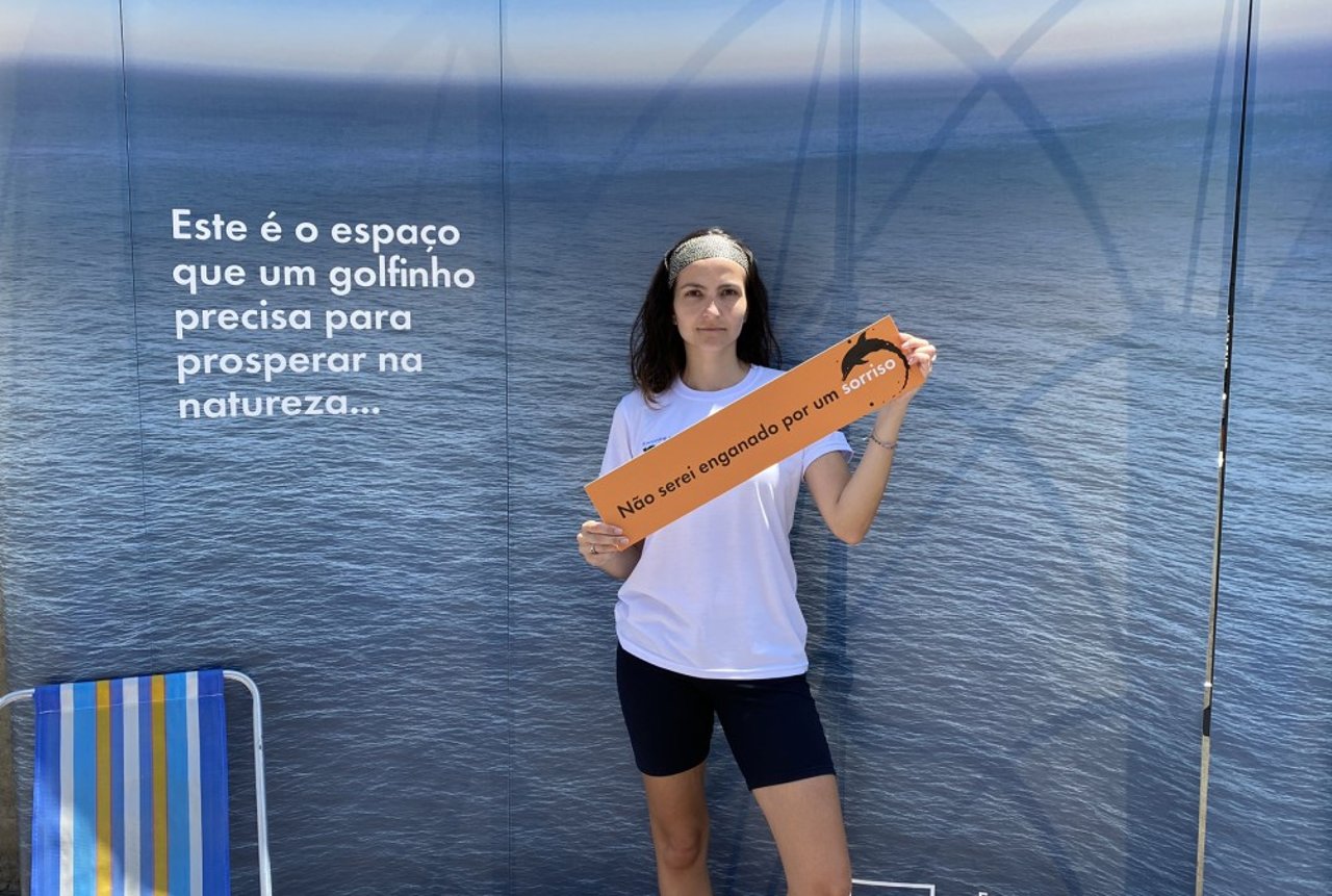 Elaine Villatoro, blogueira de turismo sustentável, segurando placa &quot;Não serei enganado por um sorriso&quot;