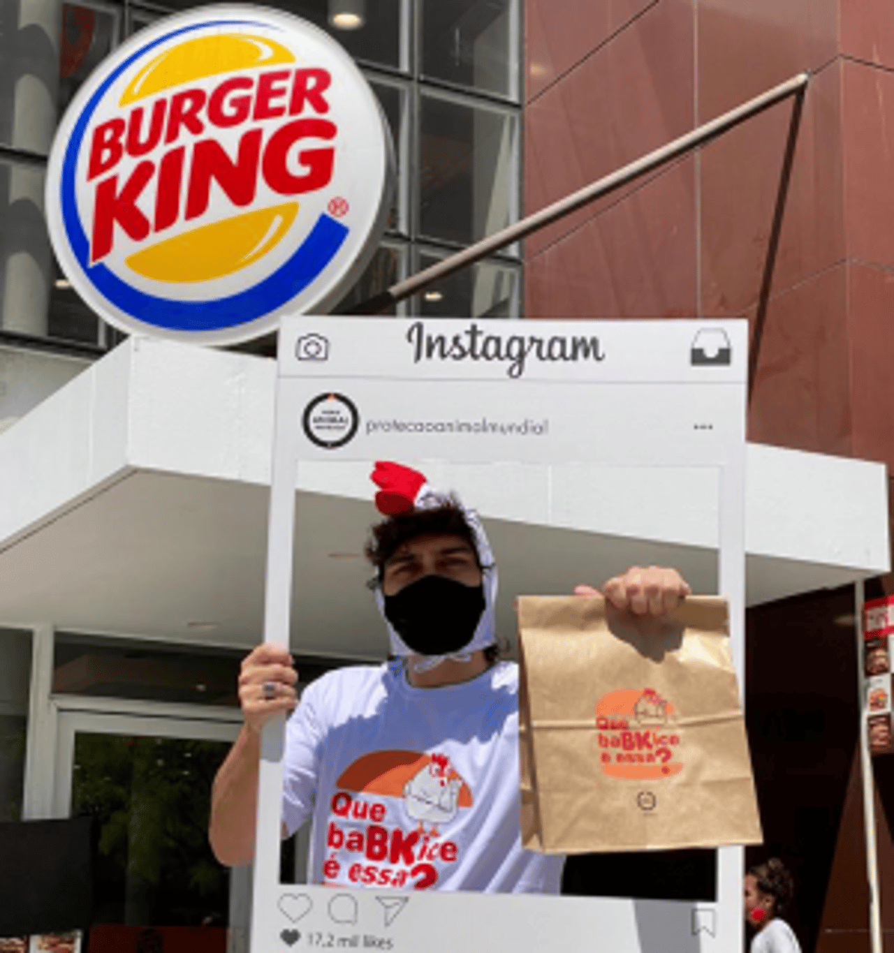Promotor de evento durante ação offline segura uma moldura do Instragam em frente ao Burger King Brasil