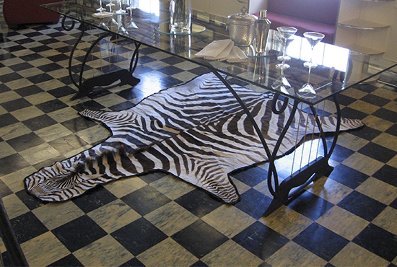 Sala com um tapete de pele de zebra embaixo de uma mesa