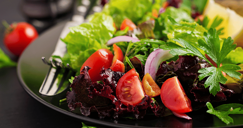 Prato de comida com folhas e tomates cortados