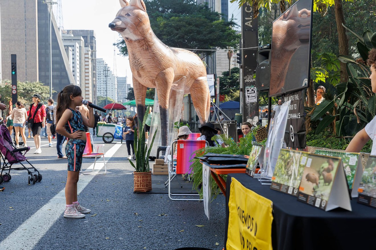Imagem de uma criança cantando no karaokê na avenida Paulista