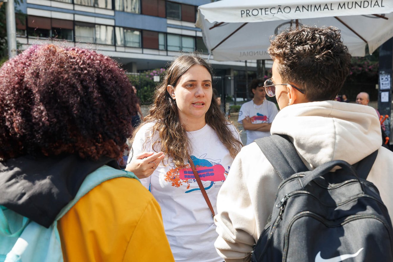 Imagem de uma representante da Proteção Animal Mundial conversando com as pessoas na avenida Paulista