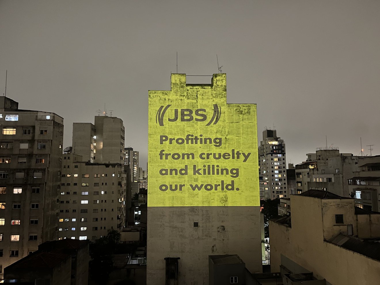 Projeção com frase de protesto em inglês contra JBS