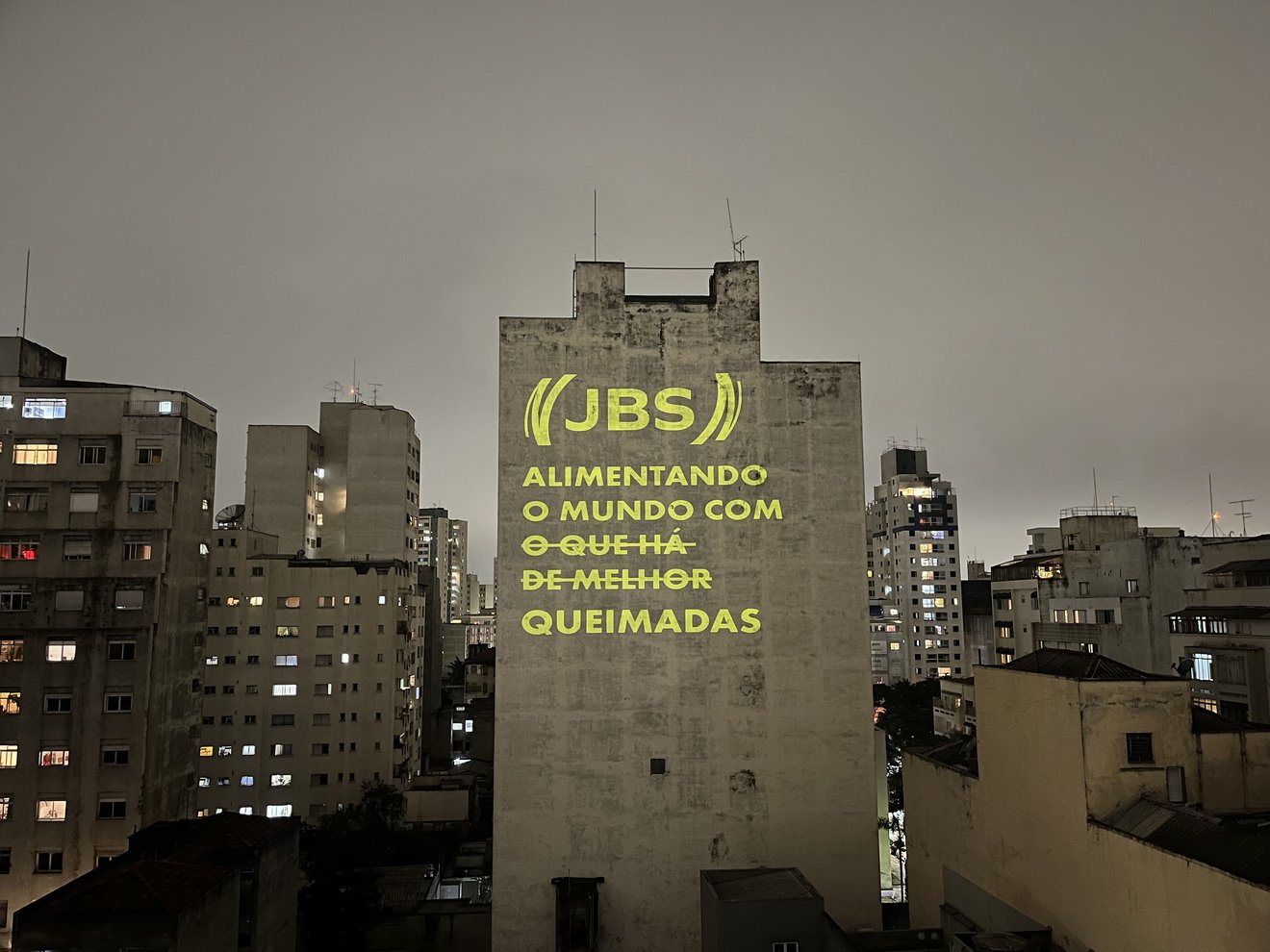 Projeção com a frase "JBS - Alimentando o mundo com queimadas"