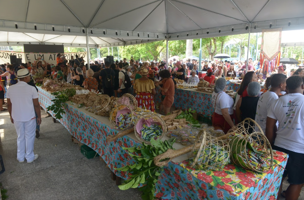 mesas grandes cheia de verduras e pessoas em volta