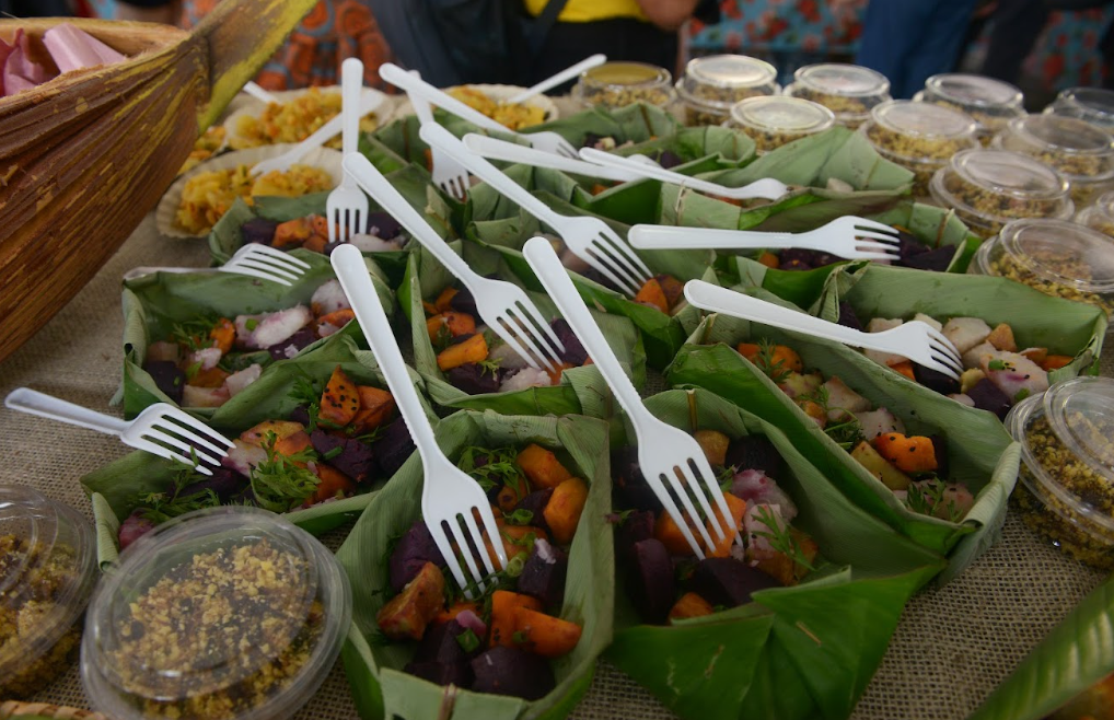 potes feito de folhas cheio de comidas e garfos em cima
