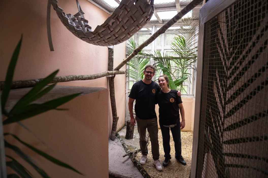 duas pessoas abraçadas dentro de um viveiro