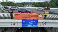Ativistas seguram banners na Ponte Piqueri, na Marginal Tietê, em São Paulo. Banners dizem: "Acionistas celebram, nós denunciamos: quem financia é cúmplice da devastação" e "Não seremos silenciados enquanto houver sofrimento animal".