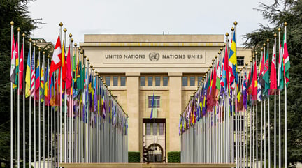Imagem da frente do prédio da ONU com bandeiras de cada lado