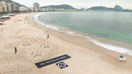 Vista aérea de esculturas em forma de pegadas de onça na Praia de Copacabana