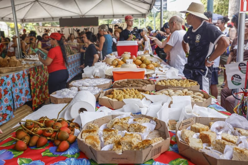 mesa farta com muitos alimentos organicos e pessoas em volta