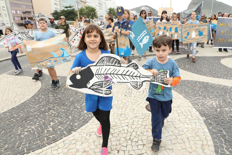 Manifestantes e crianças com cartazes caminham na Marcha pelos Oceanos, no Rio de Janeiro