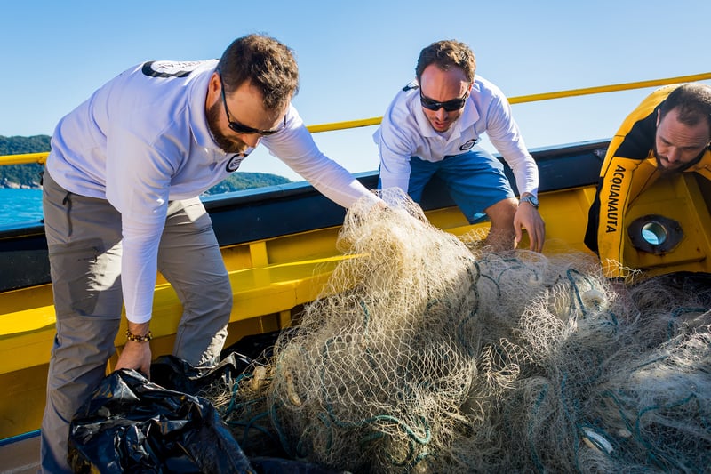 A bordo, equipe da Proteção Animal Mundial retira rede de pesca fantasma retirada do mar